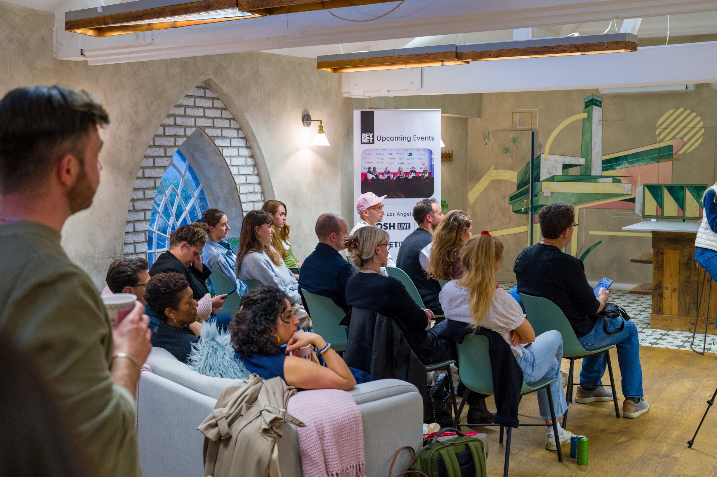 Attendees seated on chairs and a sofa, with the host visible at left.