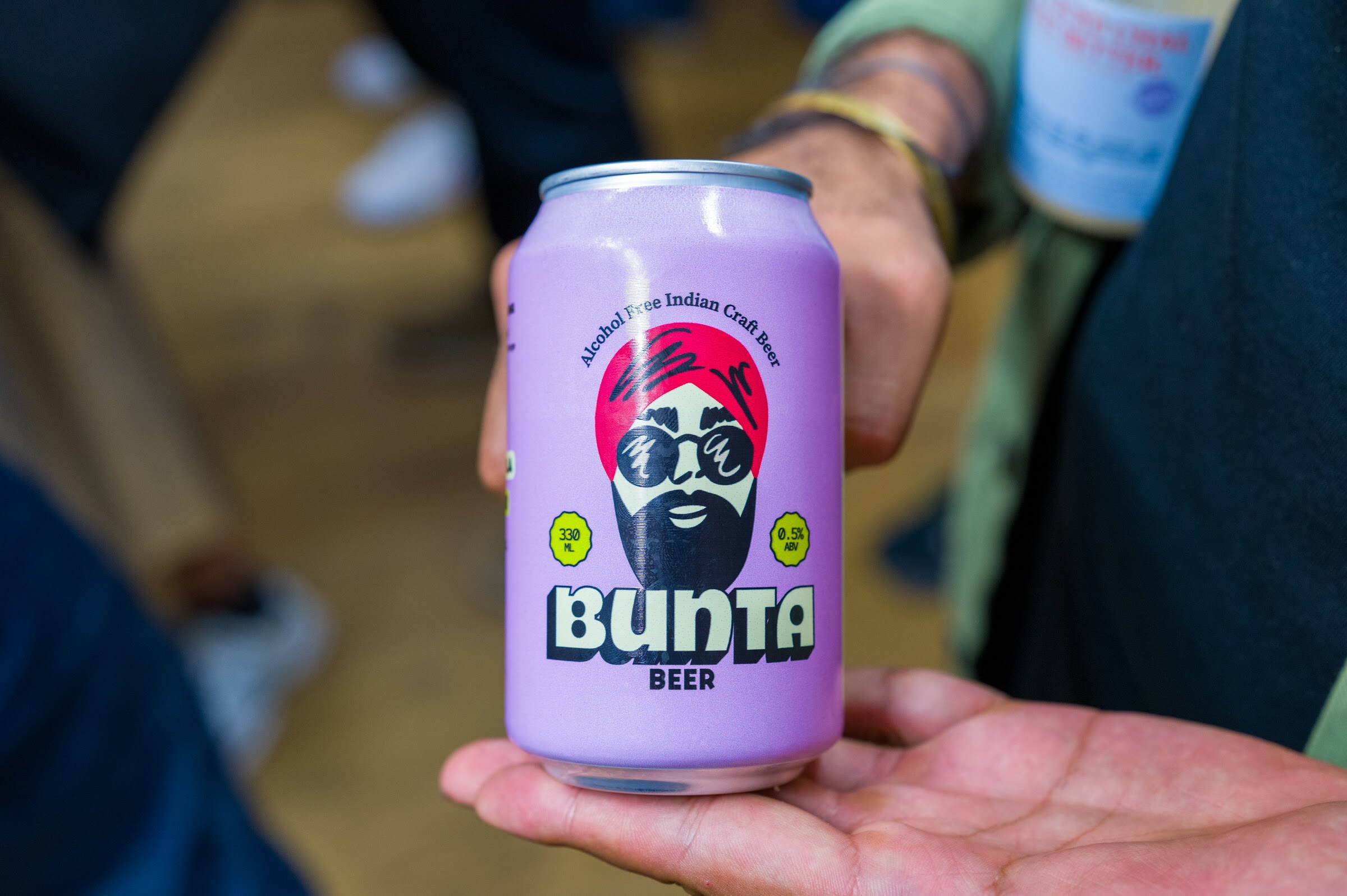 Hand holding a purple Bunta beer can with a turbaned face illustration.