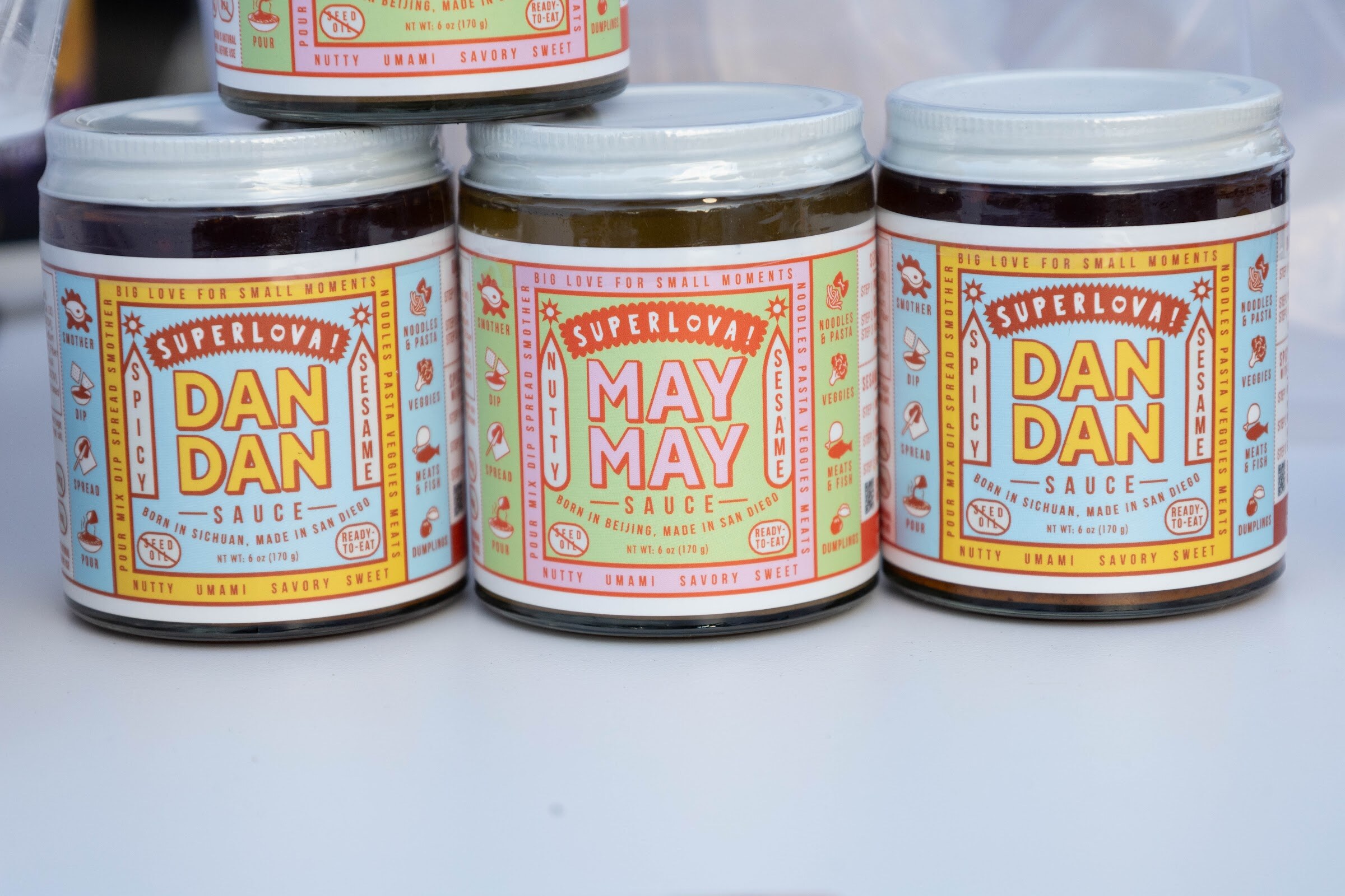 Three jars of Superlova Dan Dan and May May sauce.