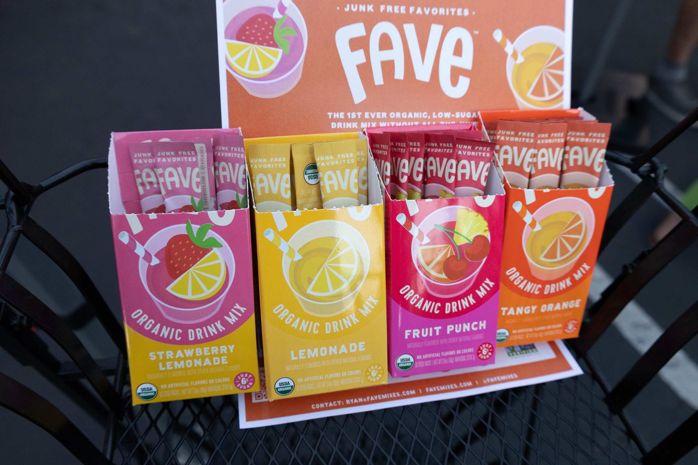 Display of Fave organic drink mix packets in strawberry lemonade, lemonade, fruit punch and tangy orange.